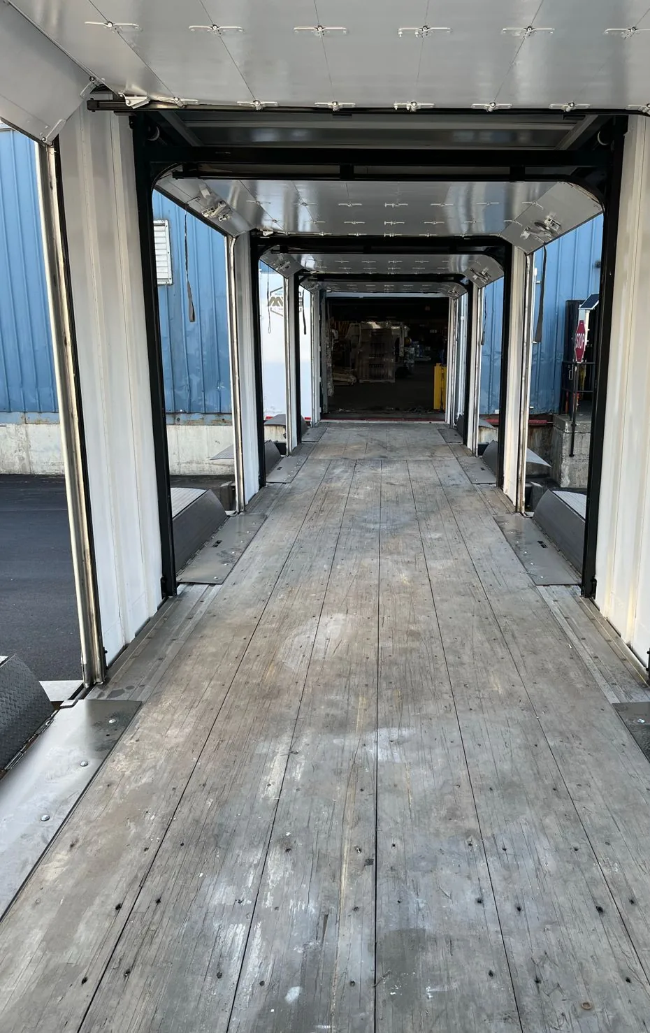 Aligned open roll-up door positions along both sides of a mobile dock interior