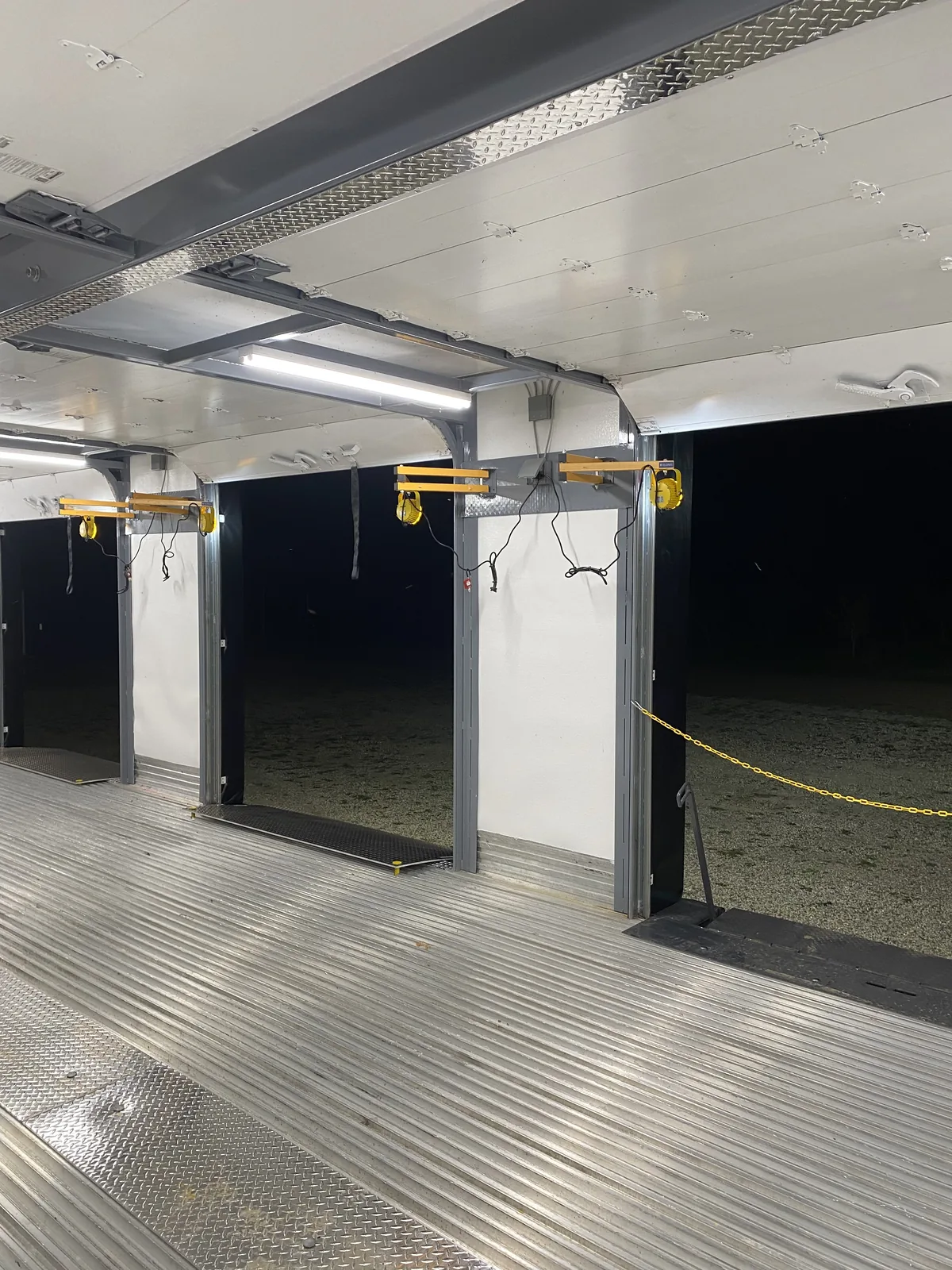 Separate overhead roll-up door tracks preserving clear working height inside a mobile dock trailer